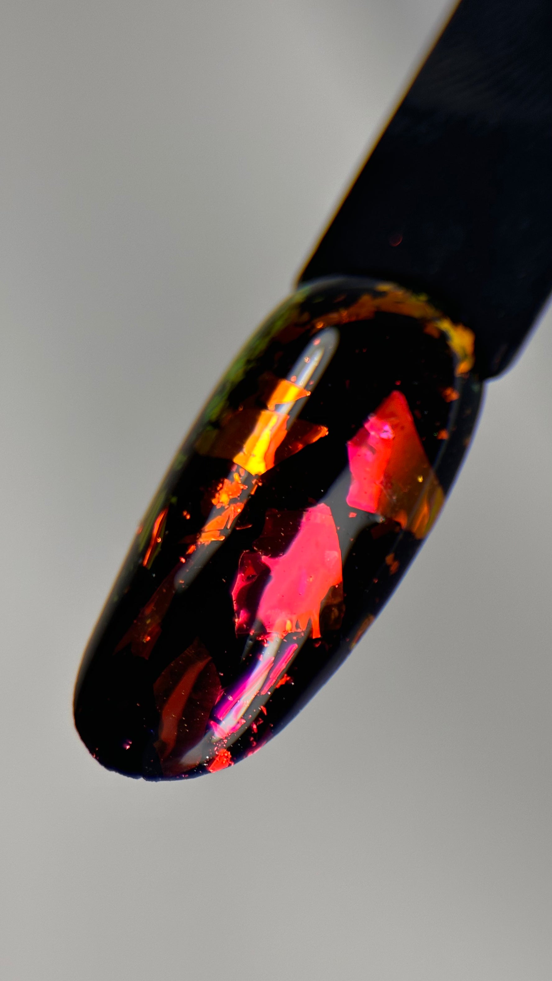 Applying MuseGel Pure Red Holographic Flakes on gel nails for a dazzling, holographic effect