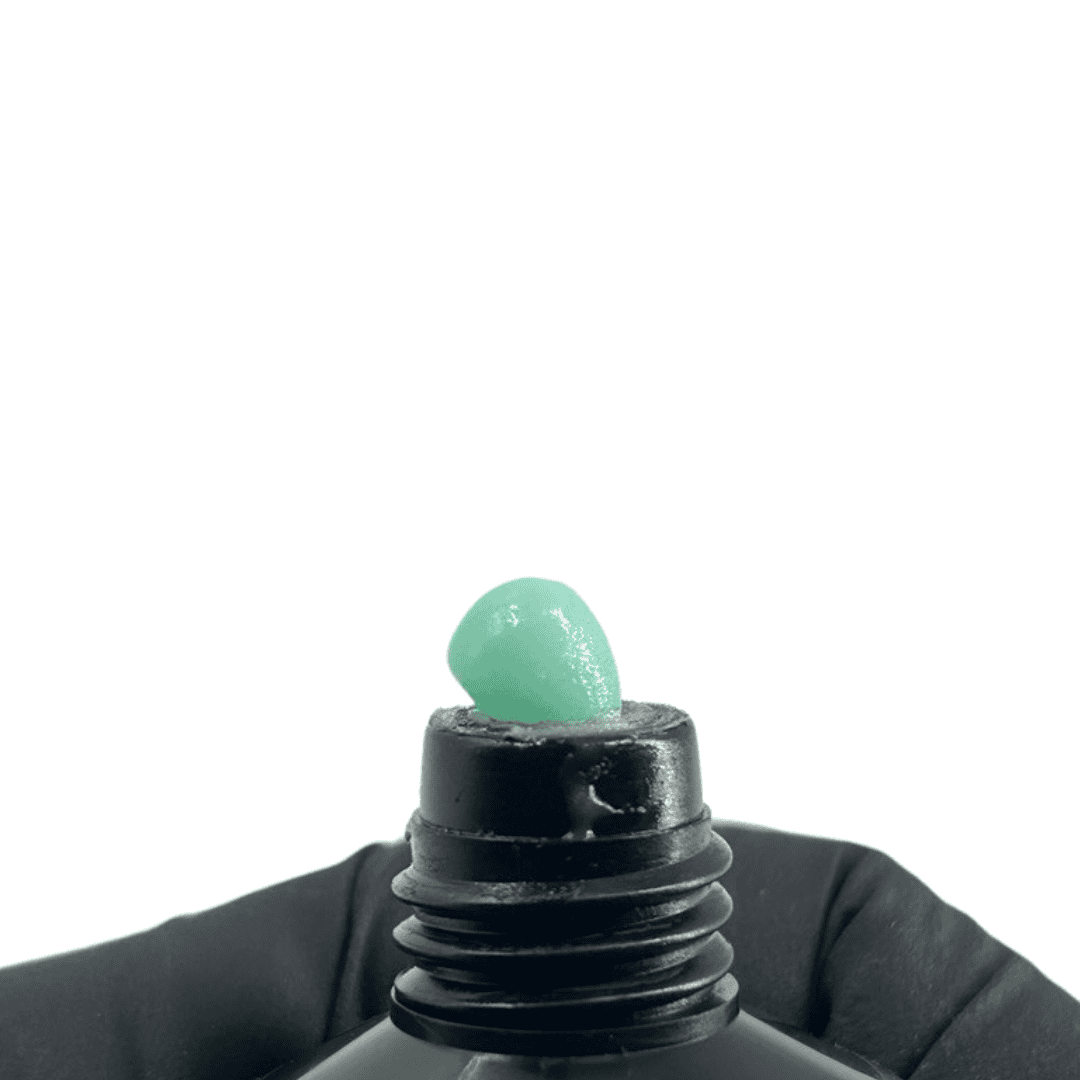 The tube dispenses a small amount of mint green polygel, demonstrating the product's consistency and vibrant color for nail enhancement.