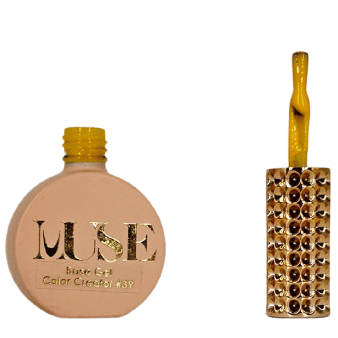 "A round nail polish bottle with a matte peach base and a bright yellow cap labeled 'MUSE Base Gel Color Creator #39'. Next to it, a yellow-handled nail polish brush with a clear stem filled with yellow glitter, placed against a background of golden rhinestones."