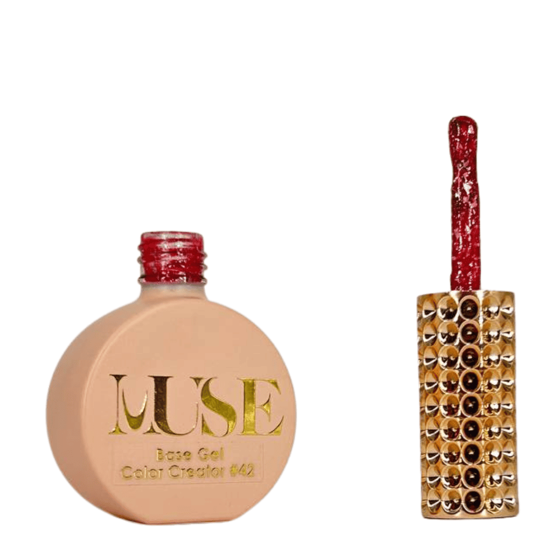 A bottle of MUSE base color gel with a number 42 label, next to its brush with a red gel on it, both placed against a white background. The bottle has a spherical shape with a flat base, and the brush handle is adorned with rows of shiny rhinestones.