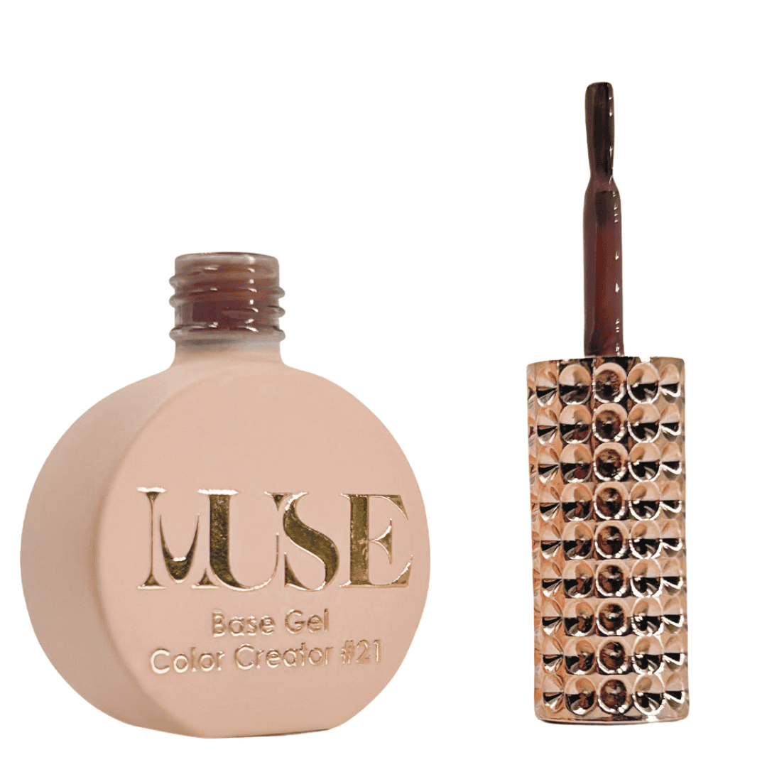 A bottle of MUSE Base Gel nail polish in a flat, round shape with a matte peach finish. The cap is a glossy maroon color, and the brush applicator is attached, adorned with multiple shiny rhinestones. The label on the bottle features the brand name "MUSE" in gold lettering with the text "Base Gel Color Creator #21" beneath it.