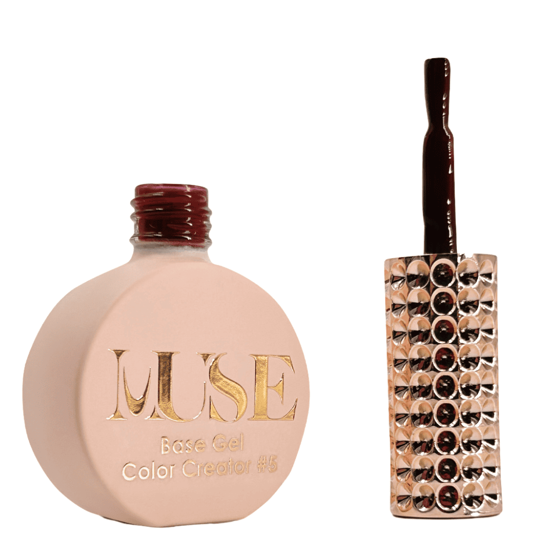 A bottle of MUSE Base Gel nail polish in a flat, round shape with a matte peach finish. The cap is a glossy burgundy color, and the brush applicator is attached, adorned with multiple shiny rhinestones. The label on the bottle features the brand name "MUSE" in gold lettering with the text "Base Gel Color Creator #5" beneath it.