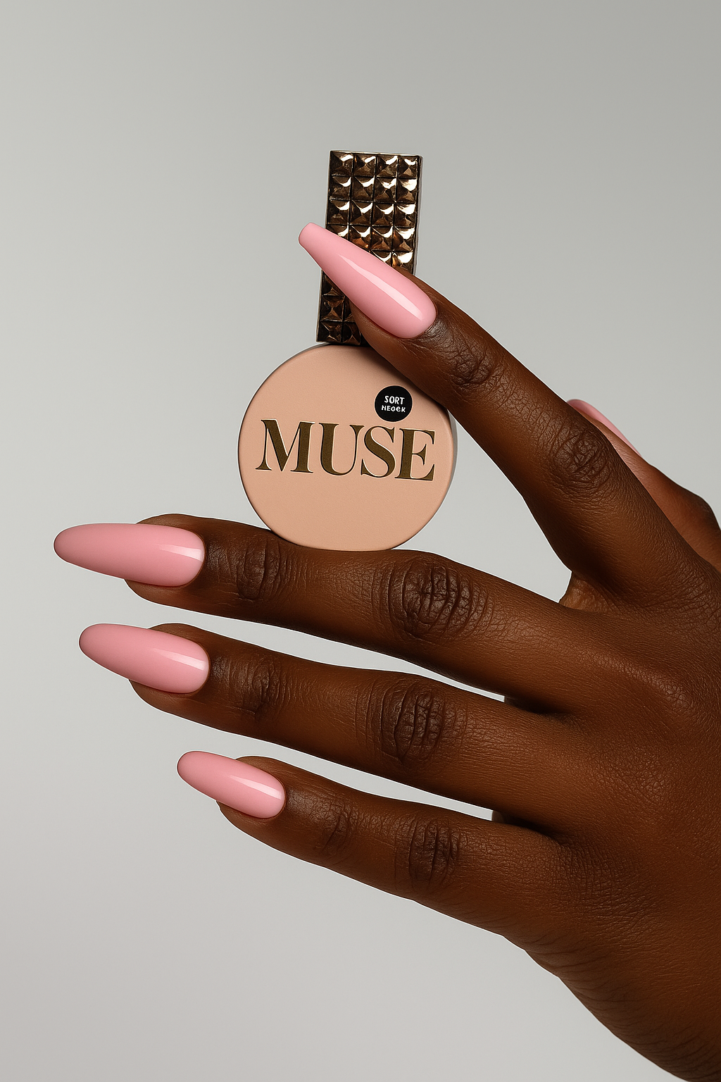 Hand holding a round beige compact with 'MUSE' branding on a neutral background