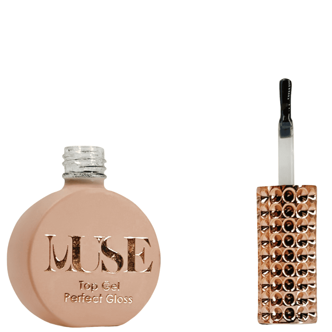 A bottle of MUSE Top Gel labeled "Perfect Gloss", featuring a flat, circular base in a matte peach shade with a clear, glittery screw cap. The brush applicator has a clear handle filled with glitter, and the front label is adorned with the MUSE logo in gold lettering, stating "Top Gel Perfect Gloss".
