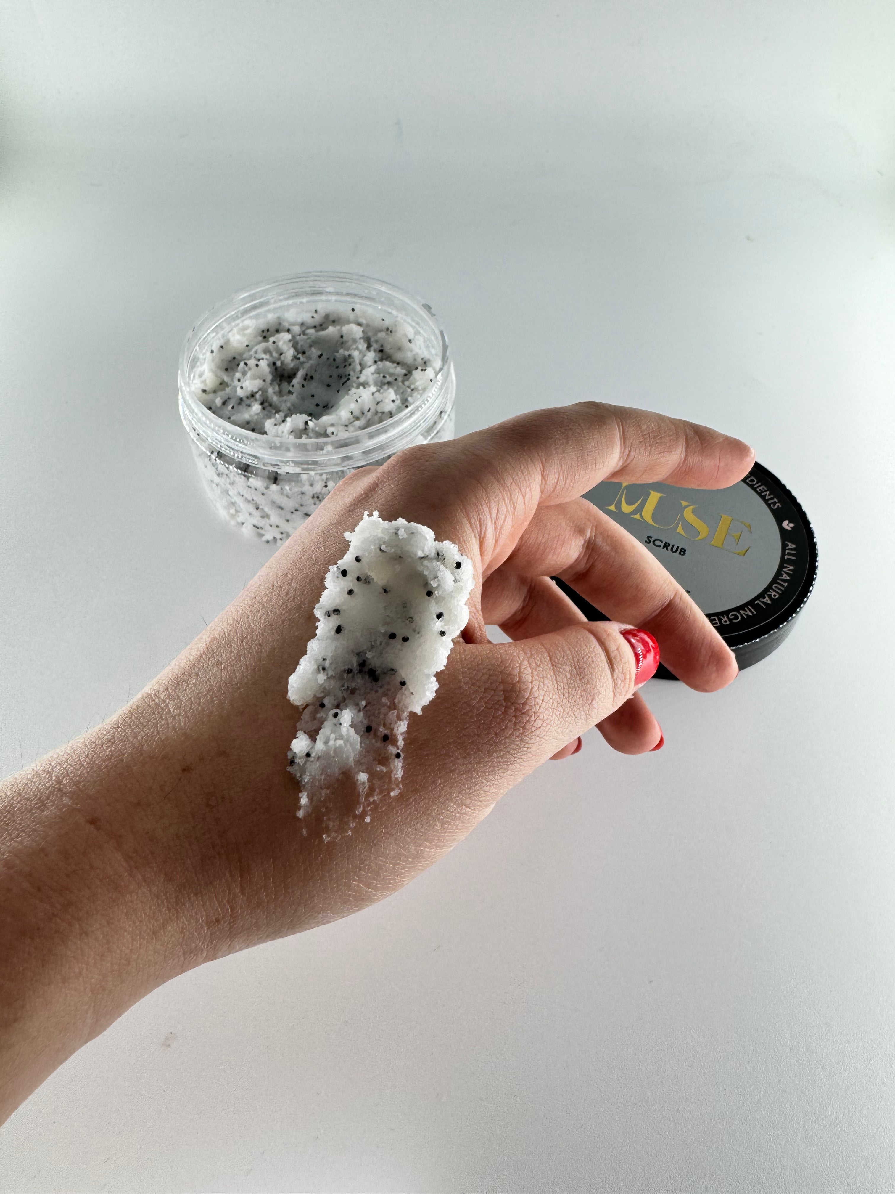 Person applying Muse Hands and Feet Scrub on their hands, demonstrating the product's exfoliating action and how it clears away old skin cells, leaving skin soft and supple.